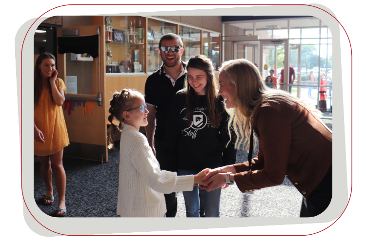 four people shaking hands and smiling